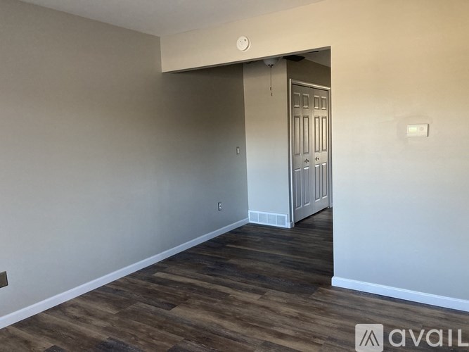 A room with a wooden floor and a white door.