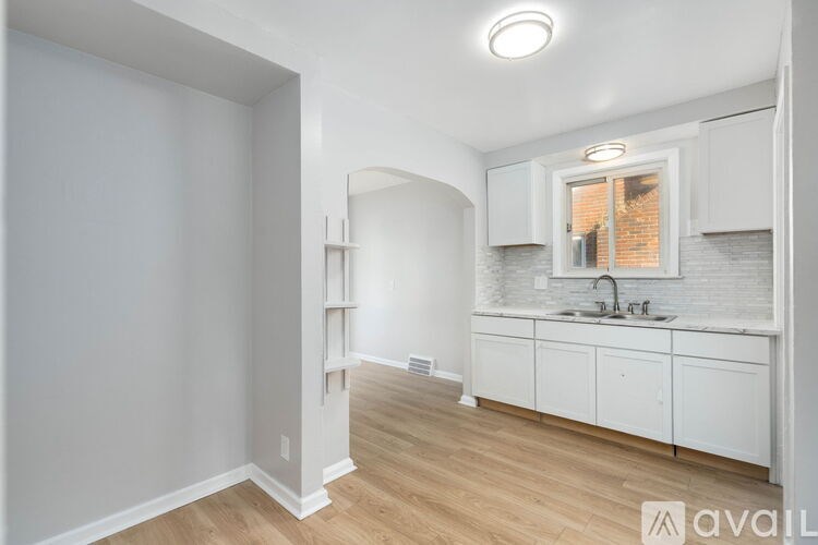 A kitchen with white cabinets and a window.