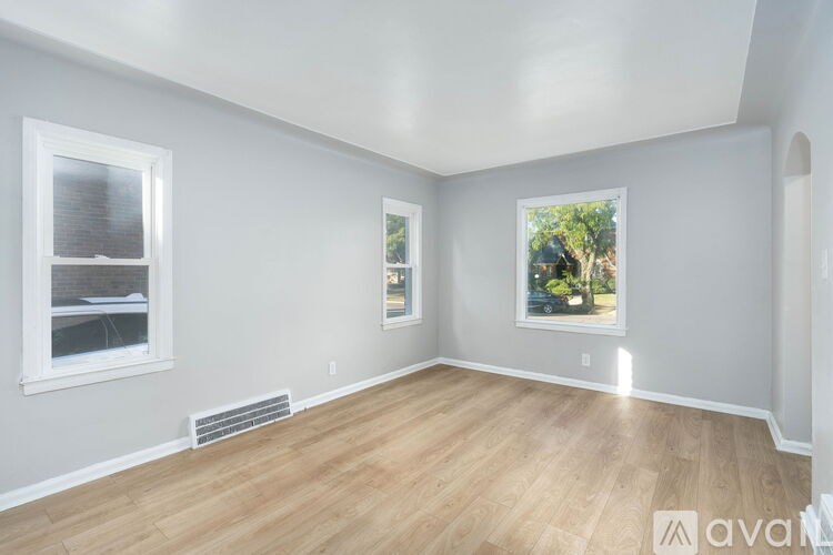 A room with wooden floors and two windows.