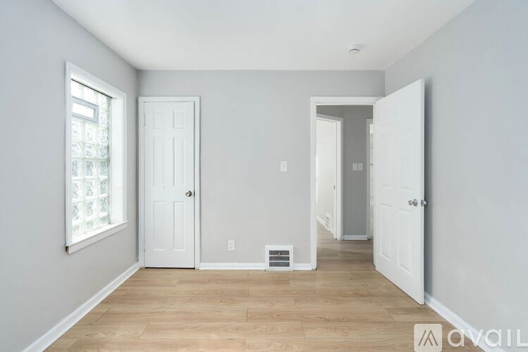 A room with a white door and a window with a white frame.