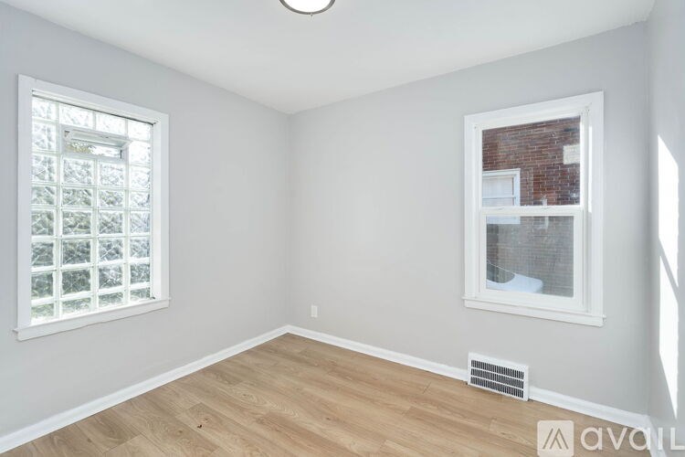 A room with a window and a wall-mounted air vent.