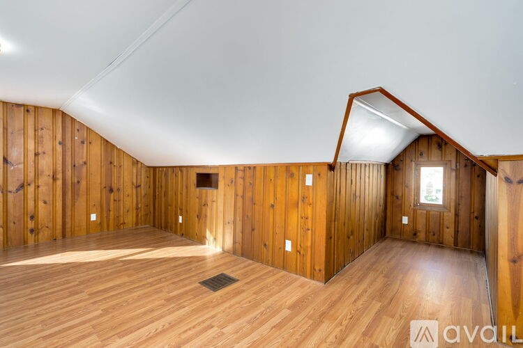 A room with wooden walls and floor and a skylight.