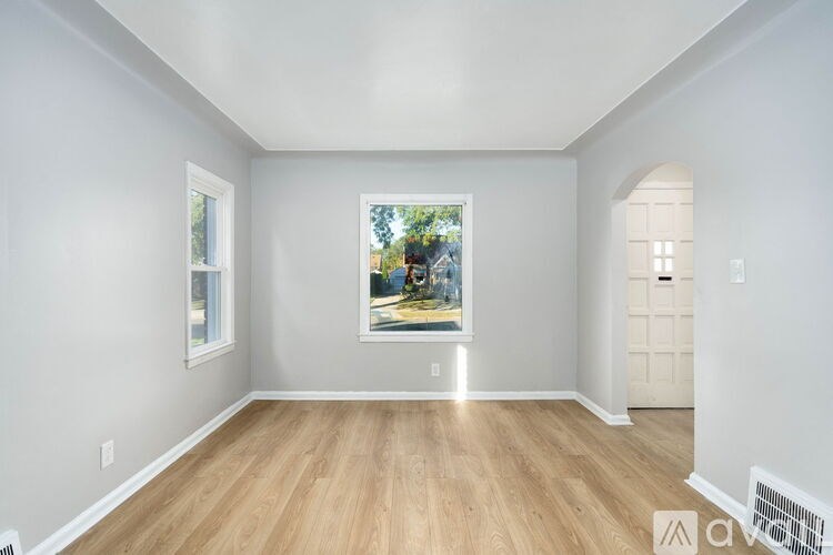 A room with a painting on the wall and a wooden floor.