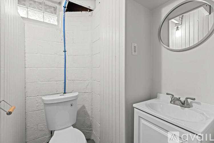 A white toilet with a blue hose attached to the wall.