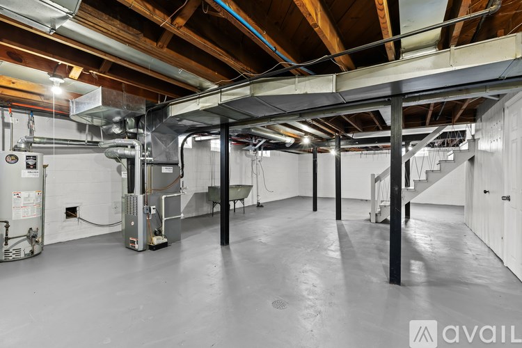 A spacious attic room with exposed wooden beams and ductwork.