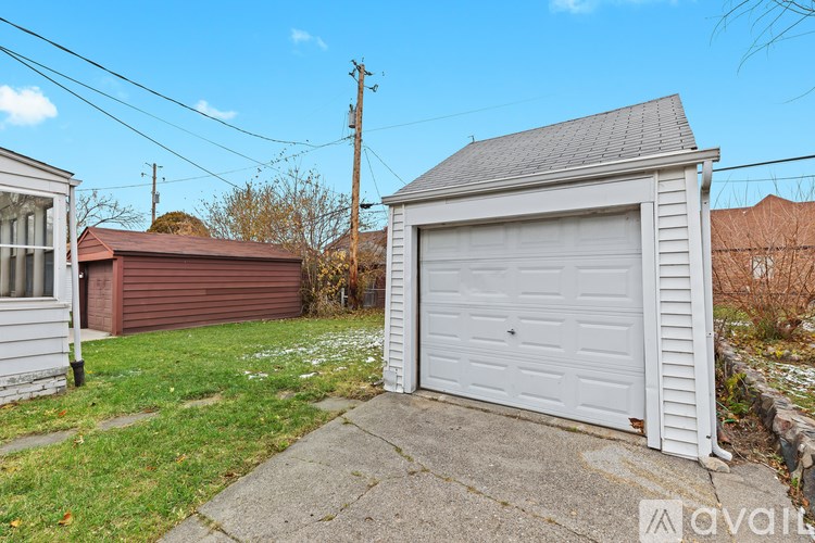 A white garage door is closed and the garage is white.