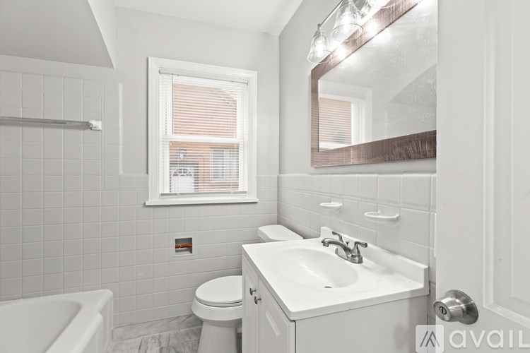 A white bathroom with a toilet, sink, and tub.