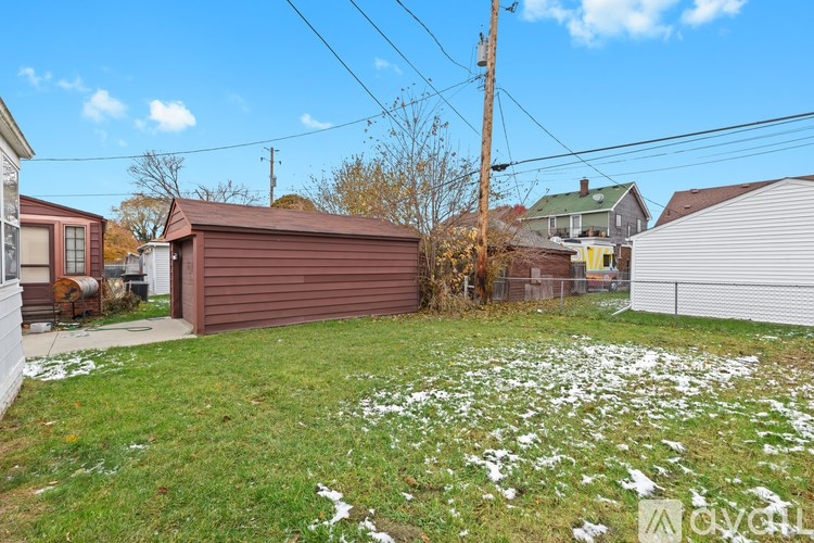 A backyard with a brown shed and a green lawn.