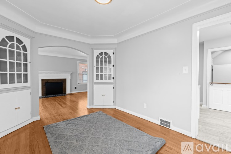 A spacious living room with a fireplace and arched doorways.