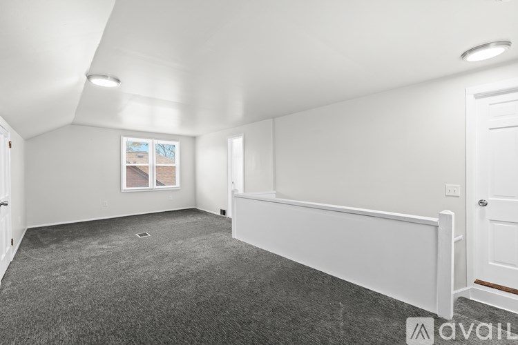 A room with white walls and a grey carpet.