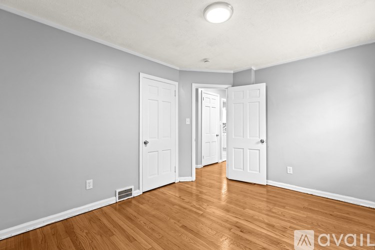 A room with wooden floors and two white doors.