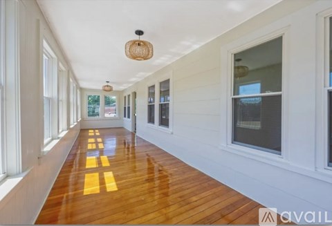 A long hallway with wooden floors and white walls.
