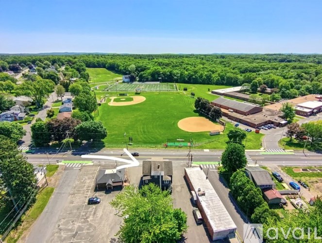 A baseball field is surrounded by buildings and trees.