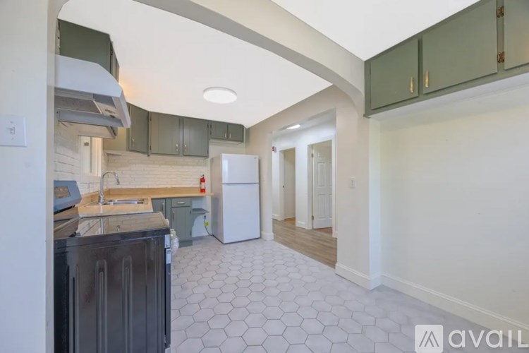 A kitchen with a white fridge and a white wall.