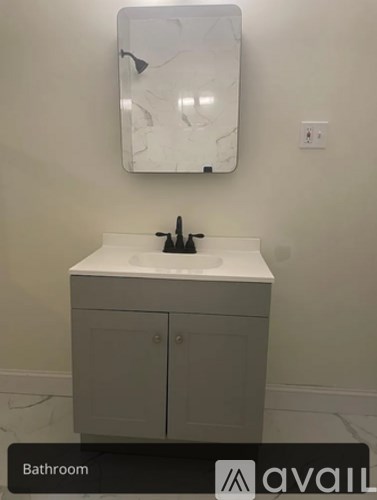 A bathroom with a sink and a mirror.