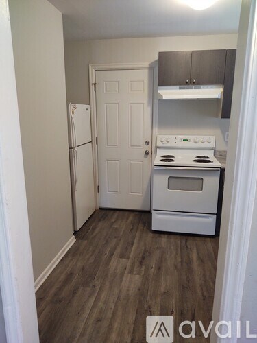 A small kitchen with a white refrigerator and stove.
