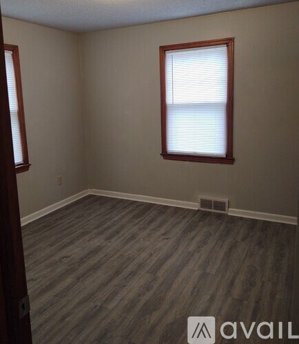 A room with a window and wooden flooring.