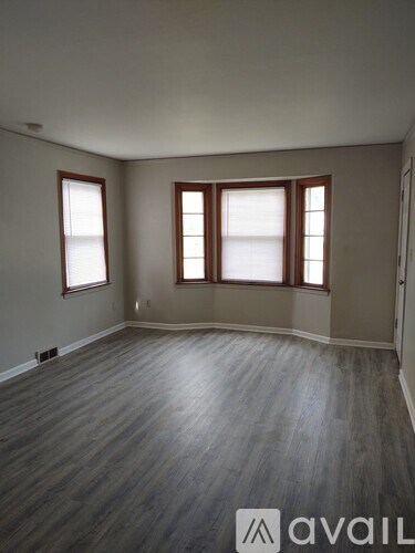 A room with wooden floors and two windows.