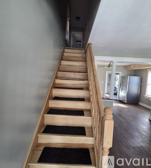 A staircase with wooden steps and a carpeted runner.