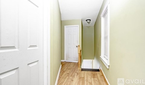 A hallway with a white door and a light green wall.