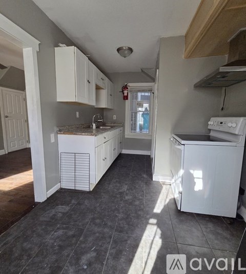 A kitchen with white appliances and cabinets.