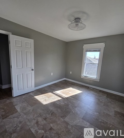A room with a tiled floor and a ceiling fan.