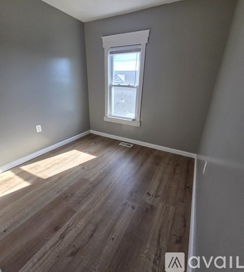 A room with wooden flooring and a window.