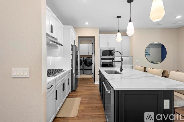 A modern kitchen with a large island and stainless steel appliances.