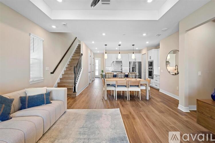 A spacious living room with a staircase leading to the upper floor.