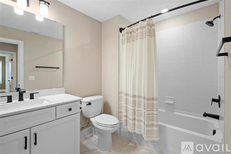 A bathroom with a toilet, sink, and bathtub.