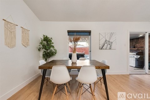 A dining room with a wooden table and white chairs.