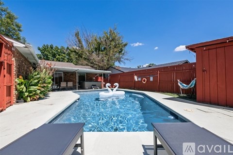 A swimming pool with a water slide and a hammock.