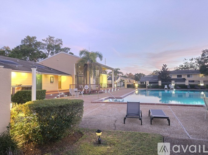 A poolside area with chairs and a building in the background.