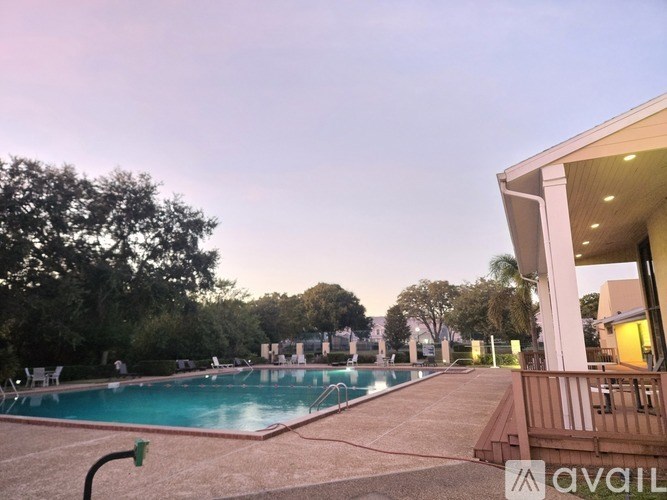 A pool with a hose attached to it and a building on the right.