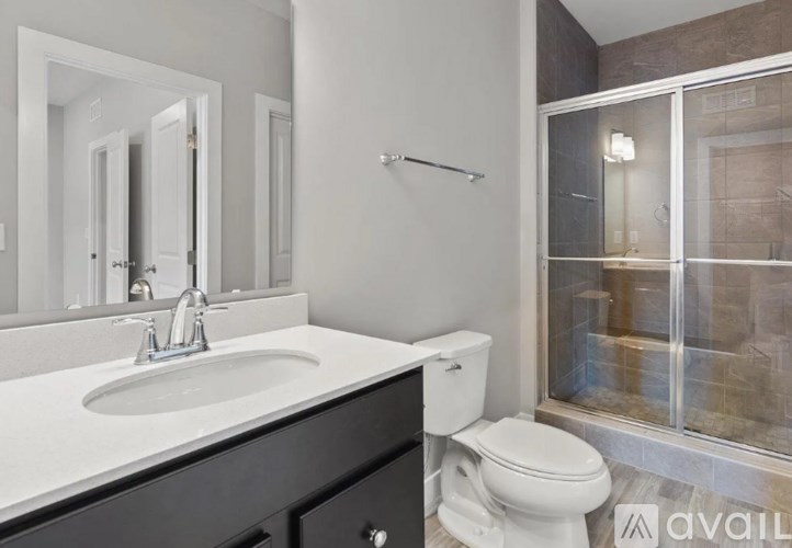 A bathroom with a sink, toilet, and shower.