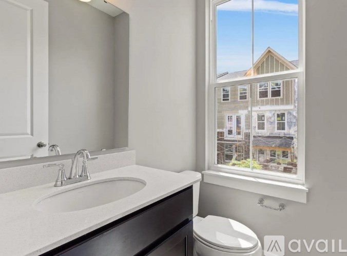 A bathroom with a window showing a building outside.