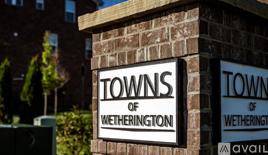 Two signs reading "Towns of Wetherington" are mounted on a brick wall.