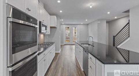 A modern kitchen with stainless steel appliances and white cabinets.