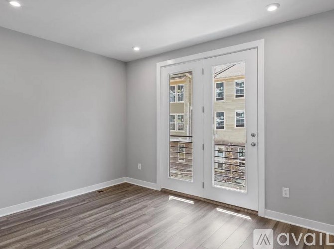 A room with a view of a building through a glass door.