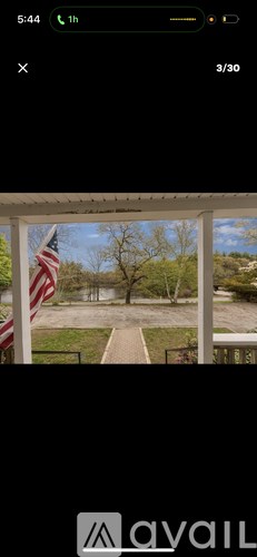 A view from a porch looking out to a tree-lined path.