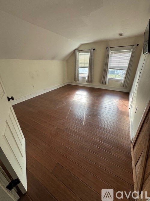 A room with wooden flooring and white walls.
