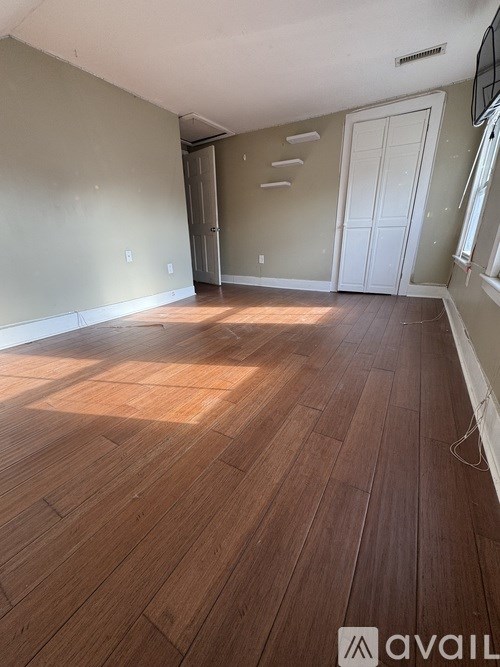 A room with wooden flooring and a white door.