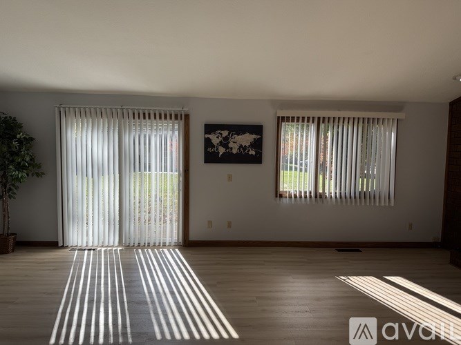 A room with a wooden floor and a painting on the wall.