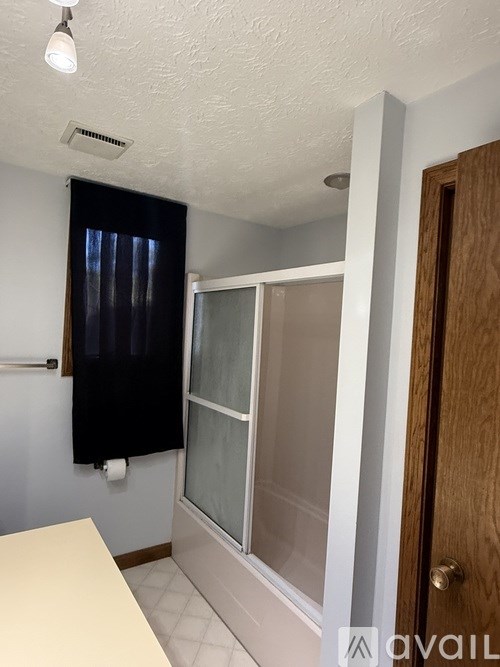 A bathroom with a toilet, sink, and shower.