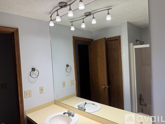 A bathroom with a sink, mirror, and light fixture.