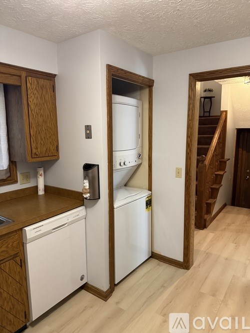 A kitchen with white appliances and wooden cabinets.