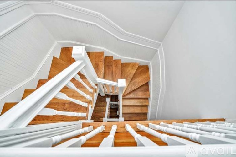 A spiral staircase with wooden steps and white railings.