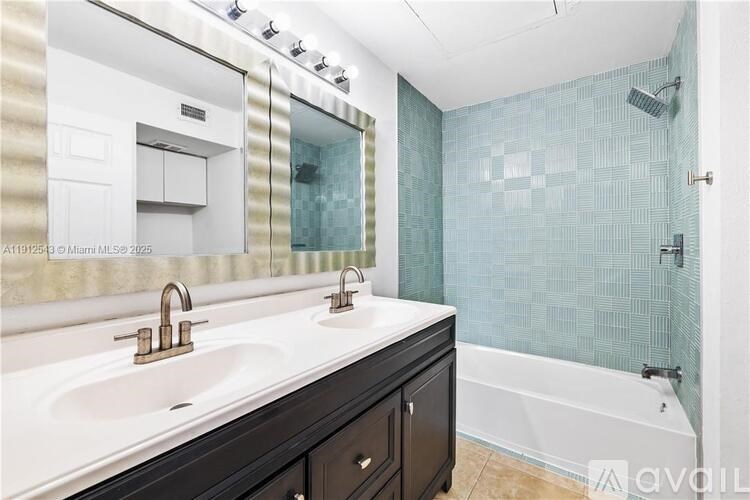 A bathroom with a white sink and a glass shower stall.