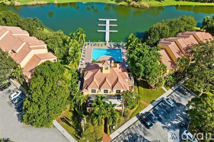 A bird's eye view of a resort with a pool and a parking lot.