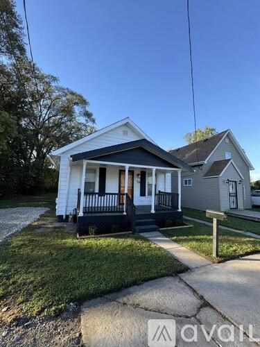 A white house with a black front porch is shown.
